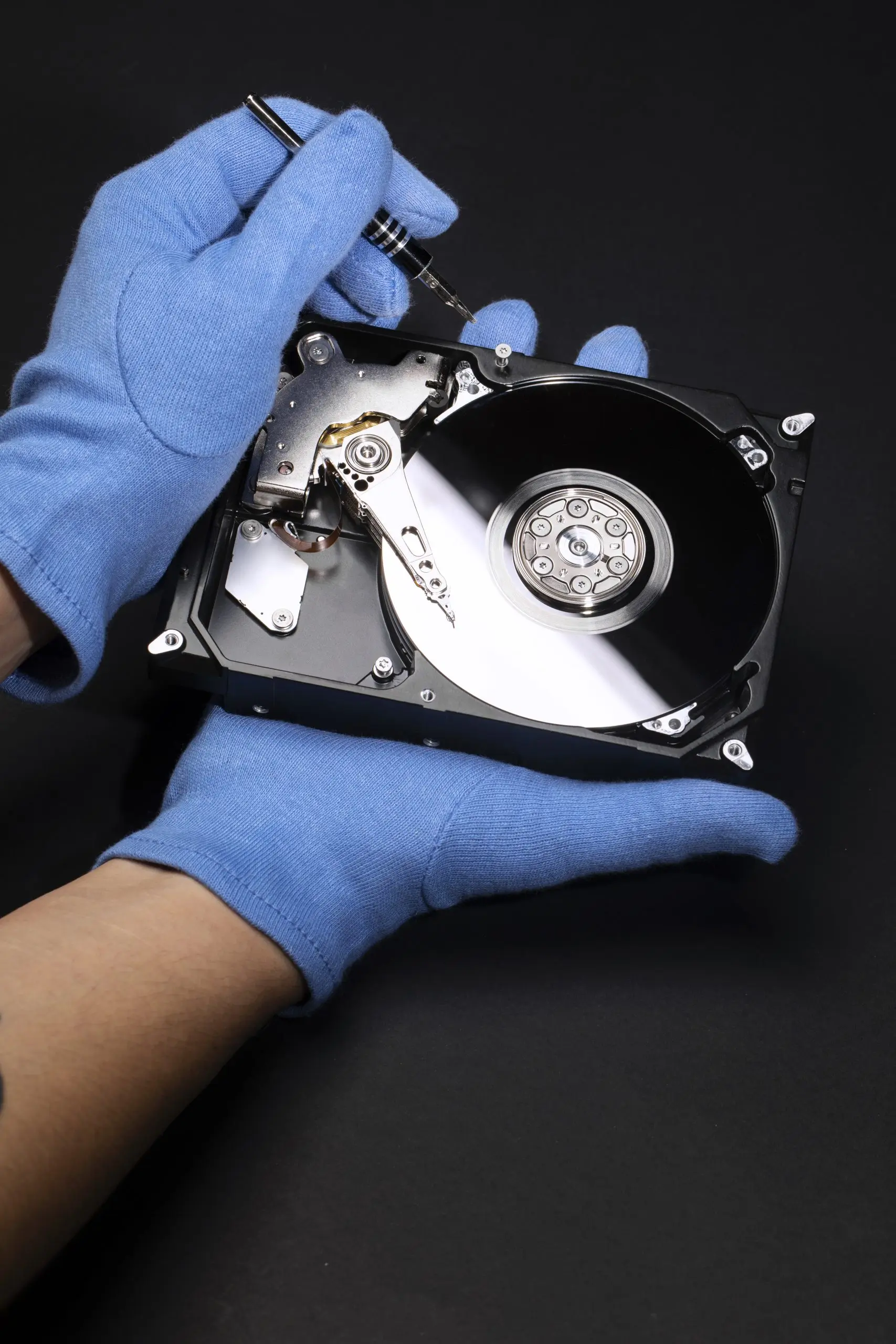 A hard drive being worked on with gloves in the data recovery laboratory